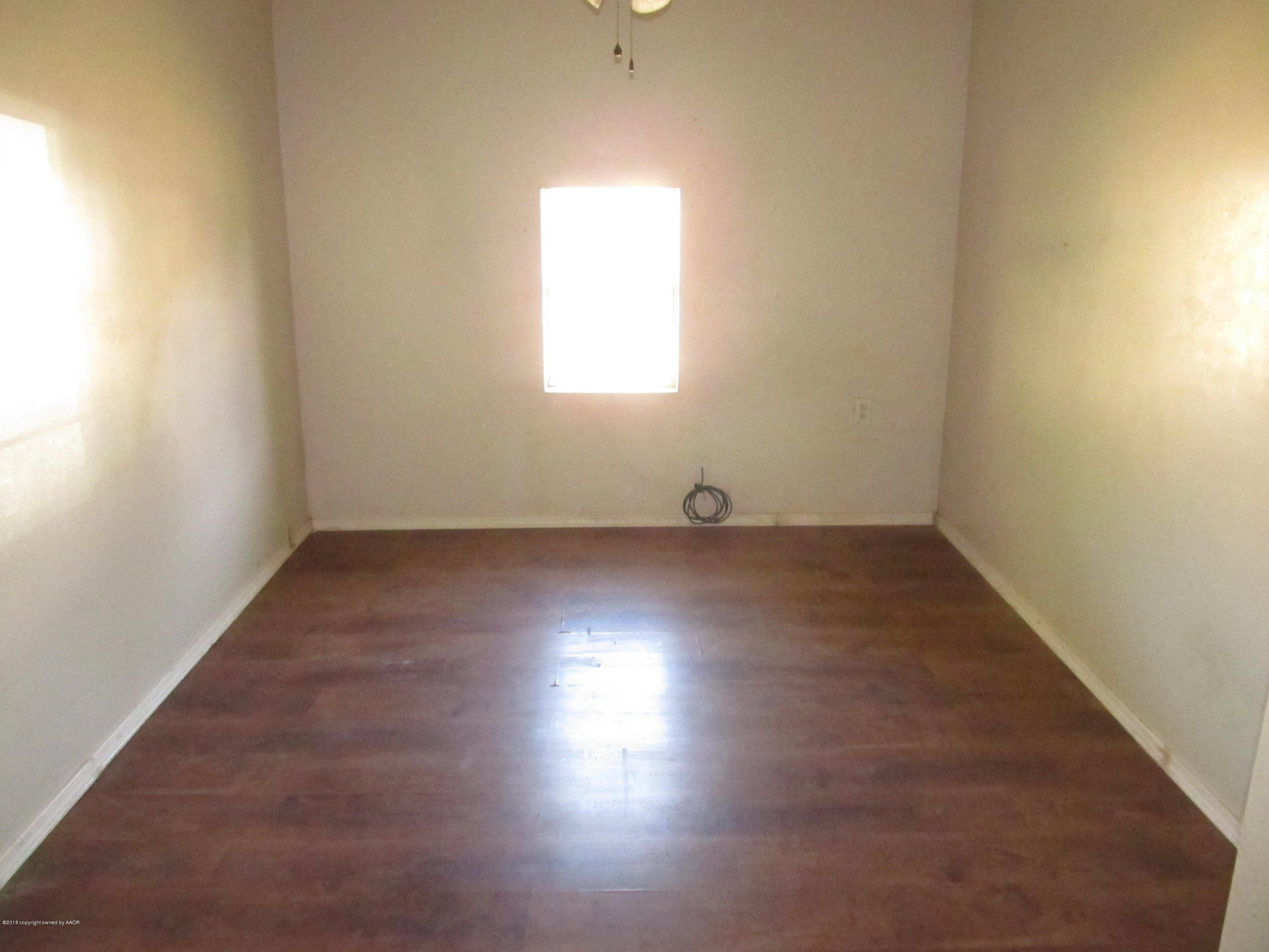 4420 South Travis Street Amarillo, TX 79110 - Photo 6 of 9 an empty room with wooden floor and windows
