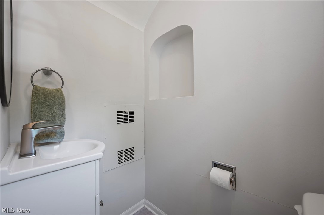 2924 Brighton Road Shaker Heights, OH 44120 - Photo 11 of 31 Half bath with vanity, toilet, lofted ceiling, and baseboards