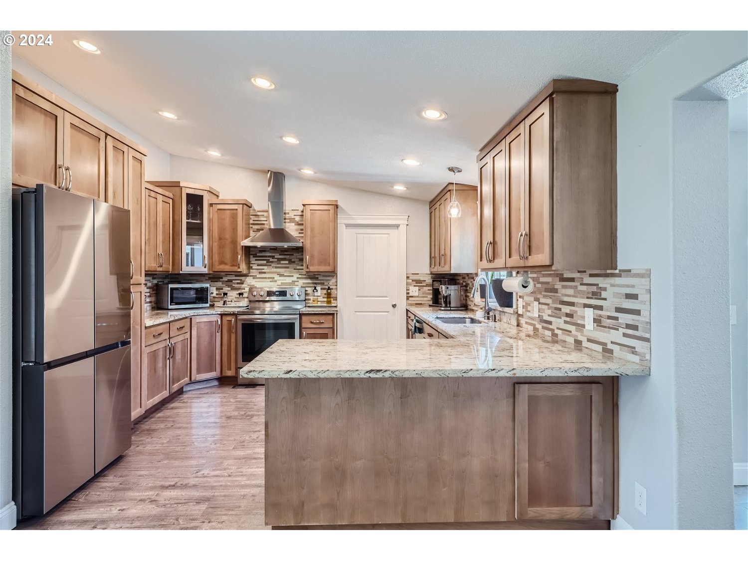 2112 Northwest 189th Street Ridgefield, WA 98642 - Photo 10 of 39 a kitchen with stainless steel appliances granite countertop a refrigerator a sink dishwasher a stove with wooden cabinets