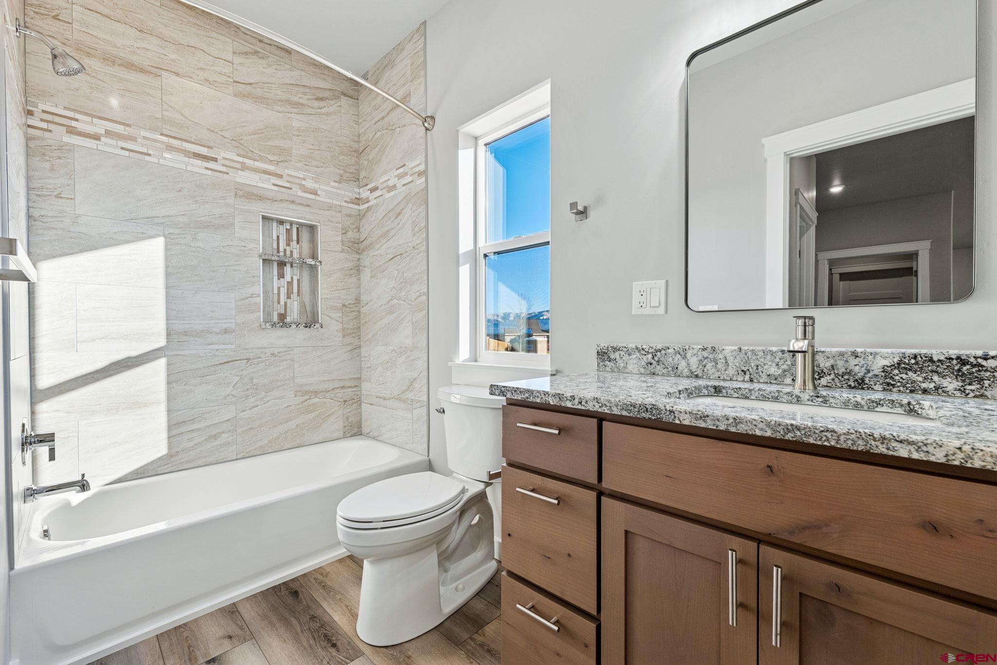 2223 Golf Course Lane Cortez, CO 81321 - Photo 14 of 26 a bathroom with a granite countertop toilet sink and mirror