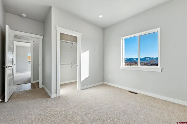 an empty room with windows and closet