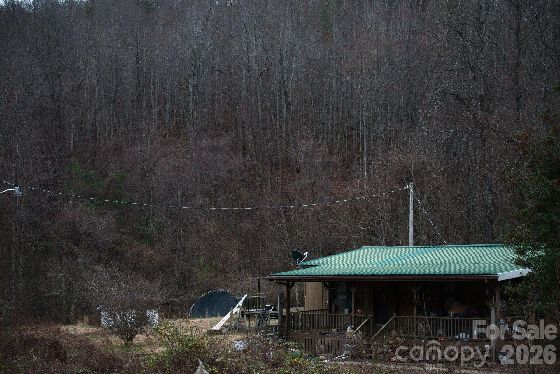5712 Holbert Cove Road Saluda, NC 28773 - Photo 14 of 17 a backyard of a house with table and chairs