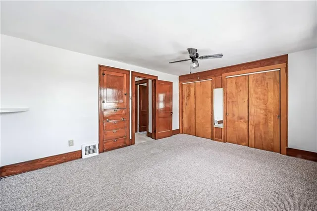 an empty room with closet and fan