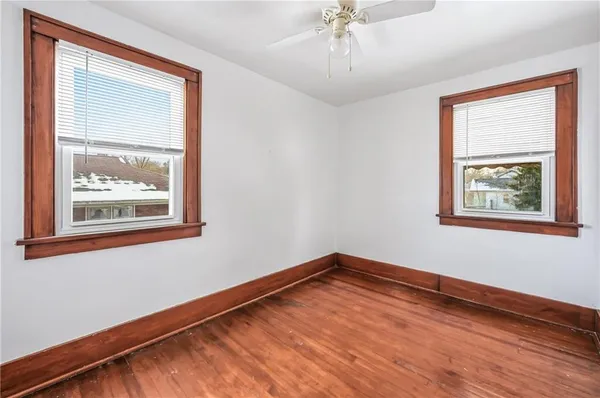 an empty room with window and ceiling fan
