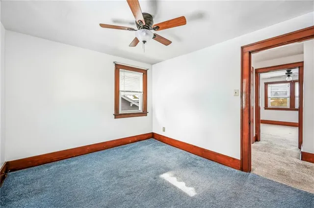 an empty room with wooden floor closet and windows