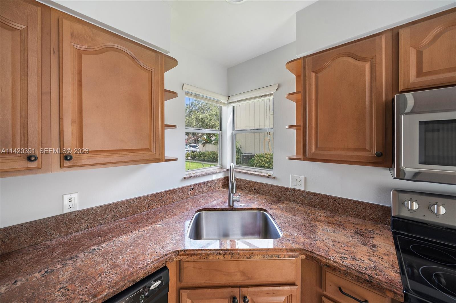 6351 Riverwalk Lane, Unit 4 Jupiter, FL 33458 - Photo 18 of 40 a kitchen with granite countertop a sink and a stove