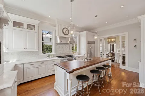 a kitchen with a stove a sink a dining table and chairs