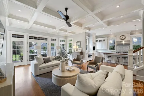 a living room with furniture kitchen view and a large window
