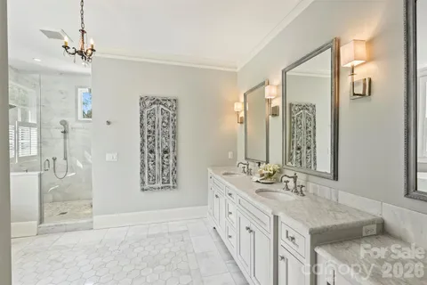 a bathroom with double vanity sinks and a shower