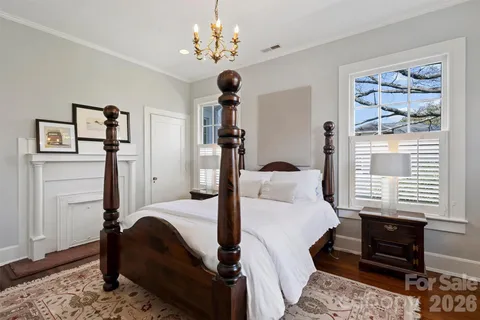 a bedroom with a bed chandelier and a window