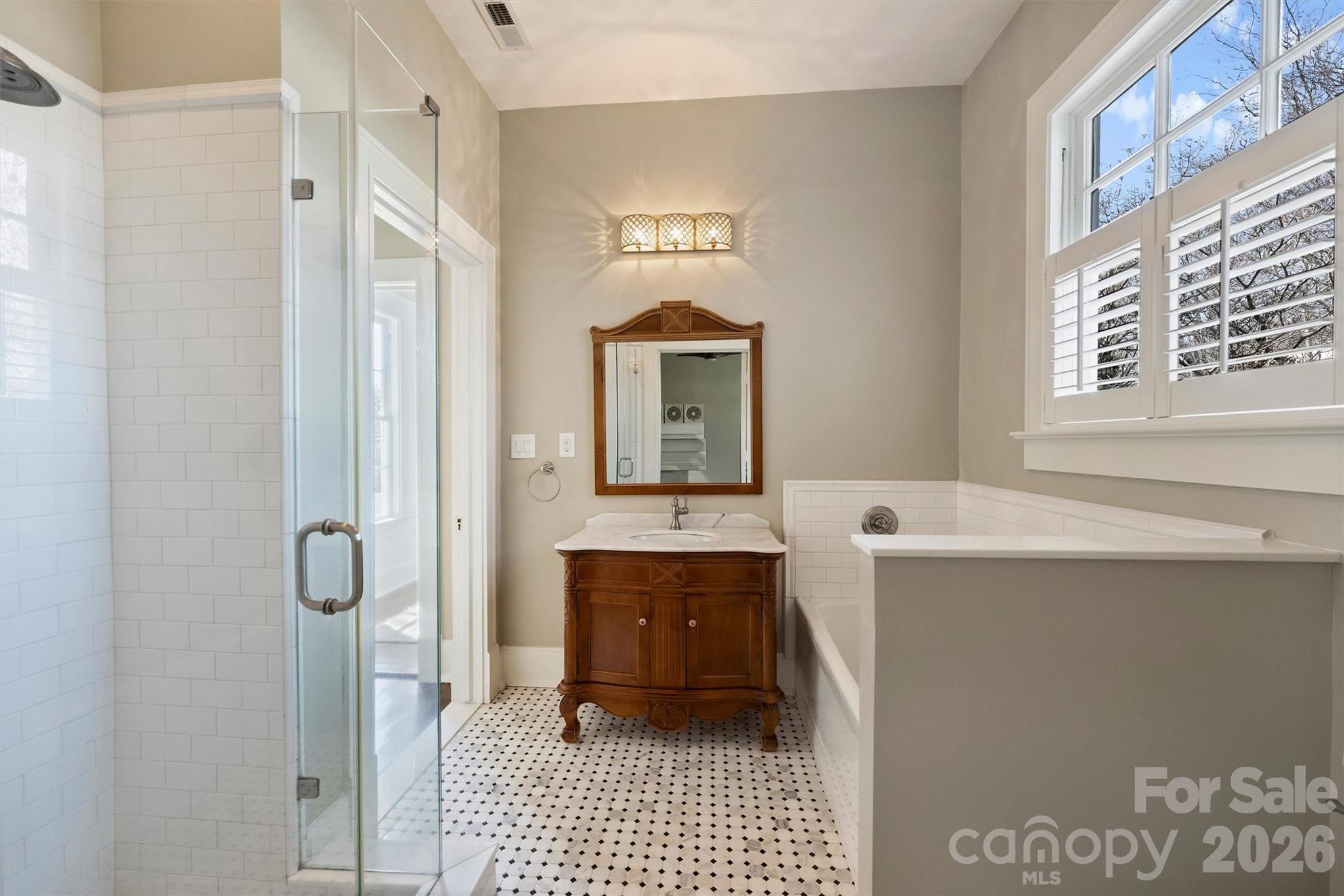 1136 Queens Road Charlotte, NC 28207 - Photo 27 of 43 a bathroom with a sink a mirror and a shower