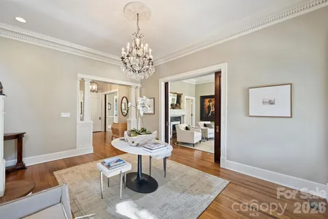 a living room with furniture a chandelier and a rug