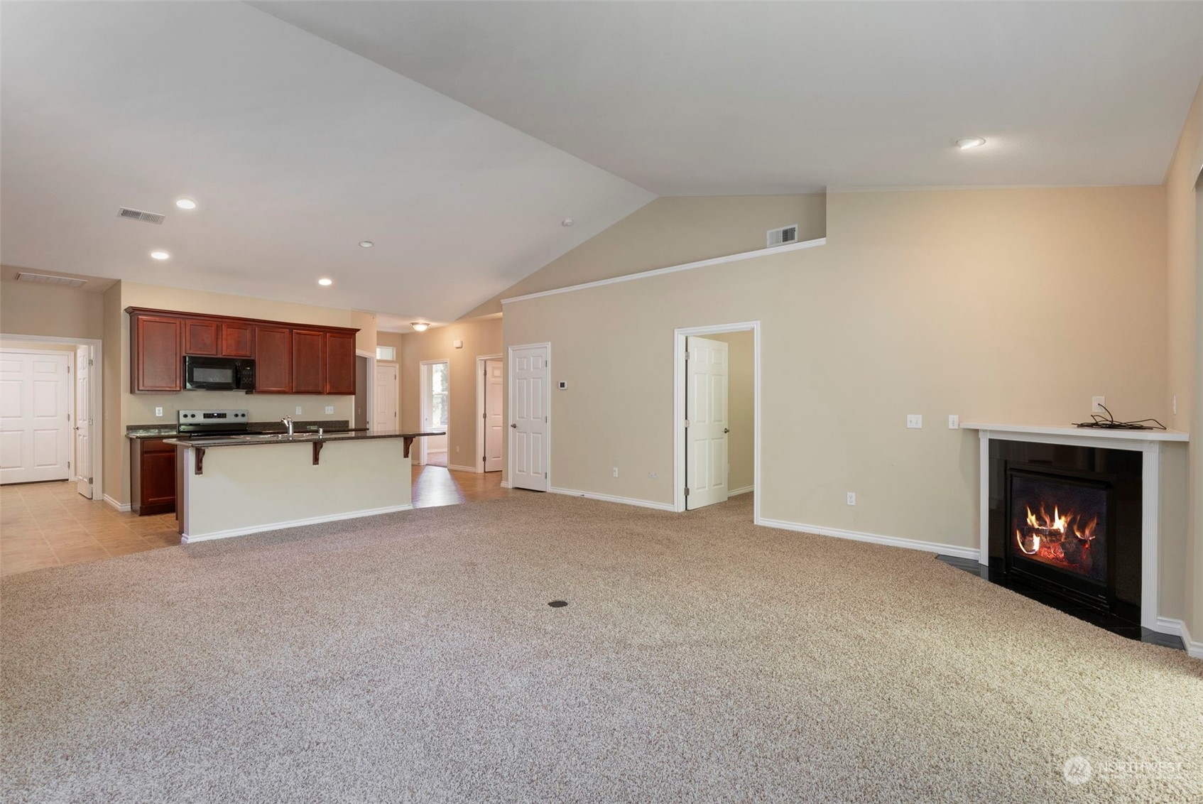 71 Pinehurst Loop Sequim, WA 98382 - Photo 8 of 32 a view of an empty room with kitchen and a fireplace