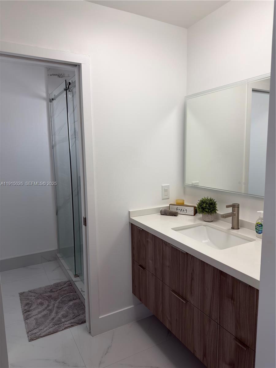 733 Southwest 99th Ct Circle Miami, FL 33174 - Photo 11 of 16 a bathroom with a sink a mirror and a shower