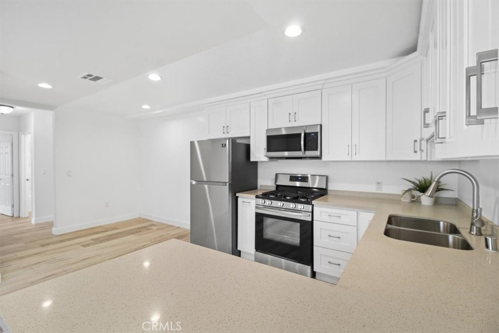 8655 Ranchito Avenue Panorama City, CA 91402 - Photo 1 of 1 a kitchen with stainless steel appliances granite countertop a refrigerator stove microwave sink and sink
