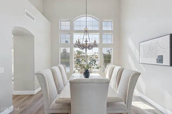 a kitchen with stainless steel appliances a sink dishwasher a refrigerator a oven and white cabinets with wooden floor