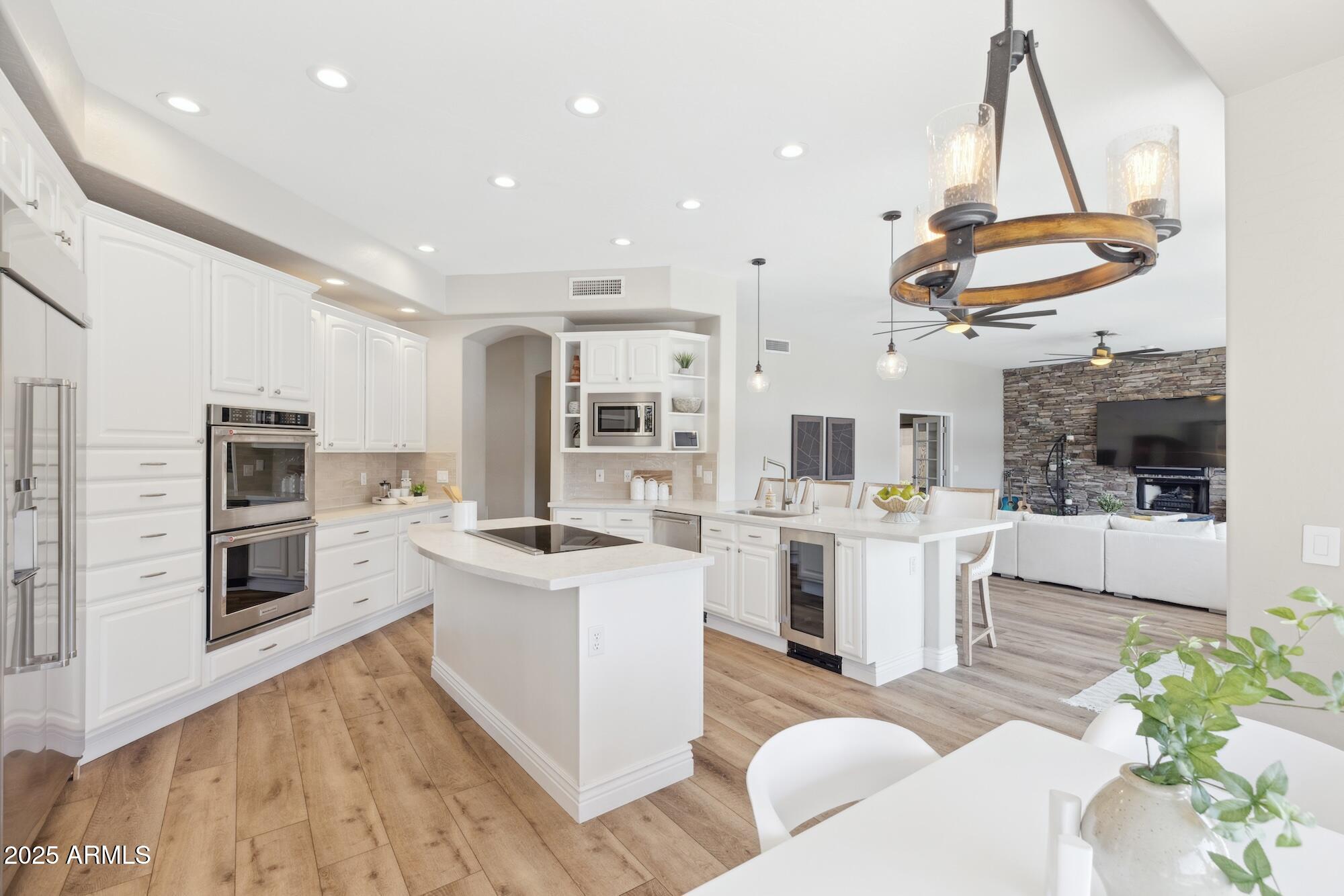 1321 West Shellfish Drive Gilbert, AZ 85233 - Photo 38 of 65 a kitchen with stainless steel appliances kitchen island granite countertop a stove a sink and a refrigerator