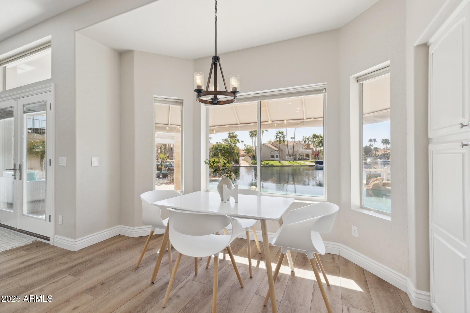 1321 West Shellfish Drive Gilbert, AZ 85233 - Photo 43 of 65 a dining room with wooden floor a chandelier a glass table and chairs