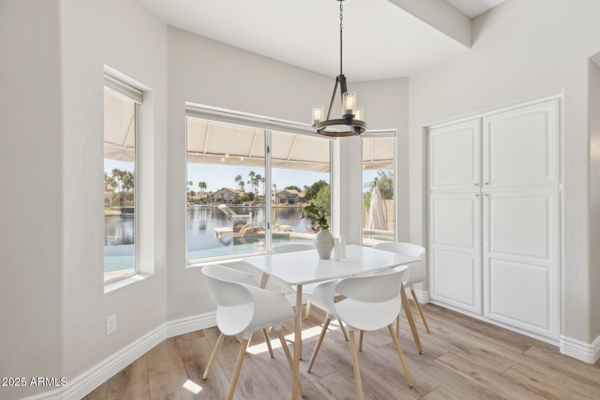 1321 West Shellfish Drive Gilbert, AZ 85233 - Photo 44 of 65 a dining room with wooden floor a chandelier a glass table and chairs