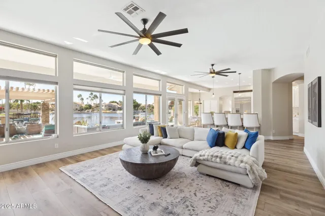 a living room with furniture a flat screen tv and a floor to ceiling window