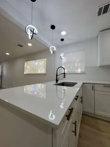 a kitchen with a sink a stove and chairs