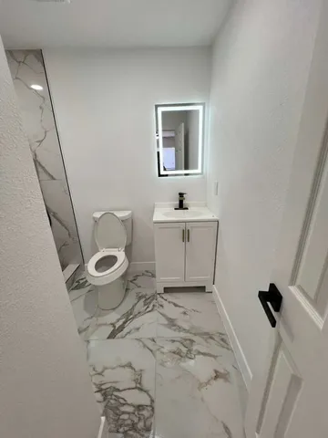 a bathroom with a toilet sink and mirror