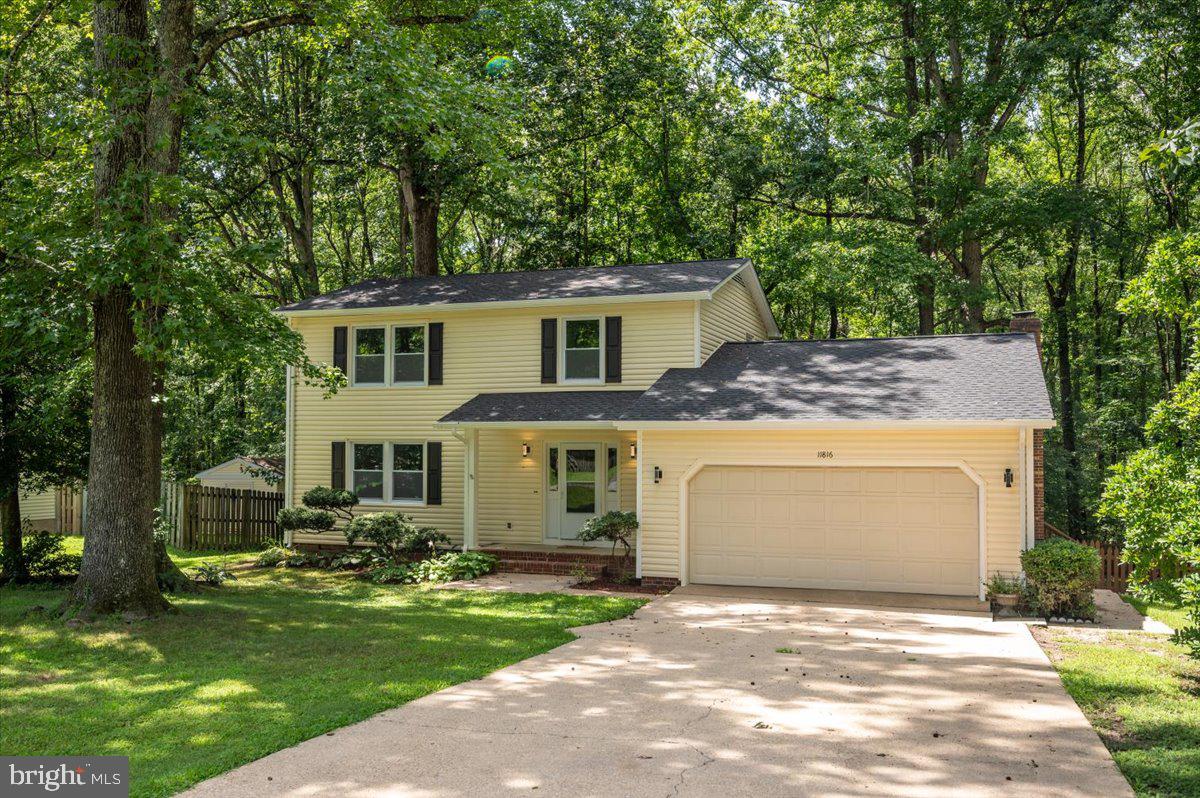 11816 Rutherford Drive Fredericksburg, VA 22407 - Photo 2 of 64 a front view of a house with a garden and tree