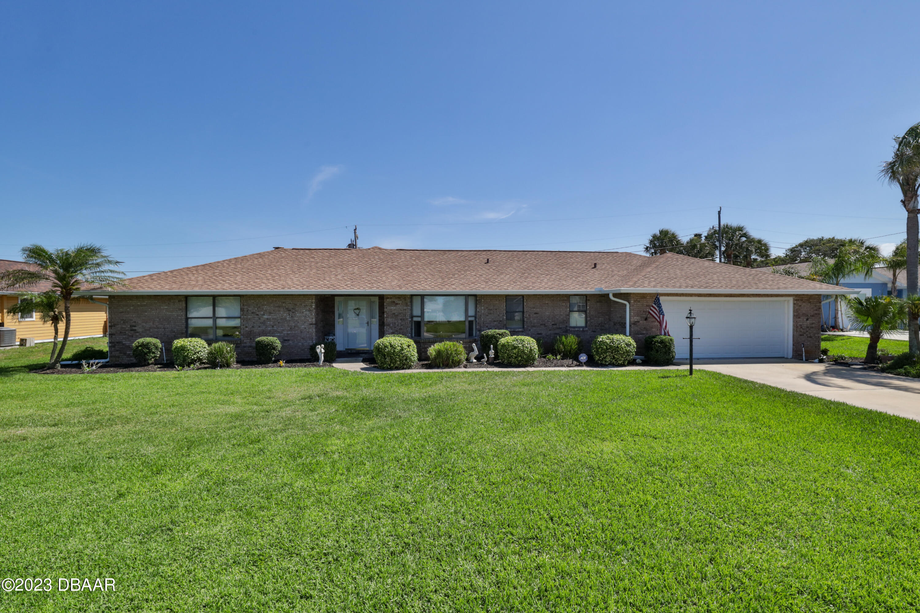 a front view of a house with a yard and a garage