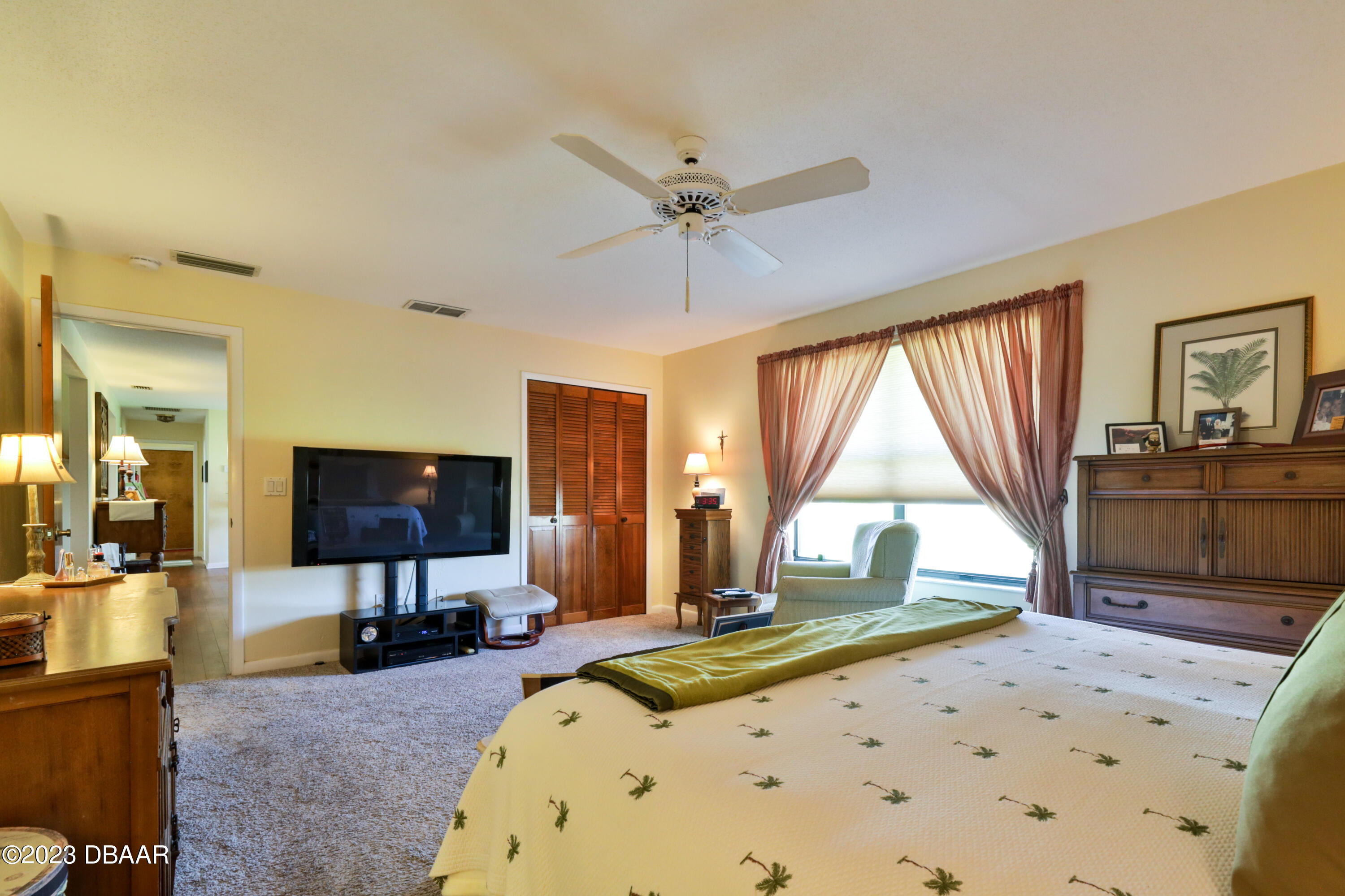 118 Sand Dunes Drive Ormond Beach, FL 32176 - Photo 28 of 46 a large bedroom with a bed and a flat tv screen on the dresser