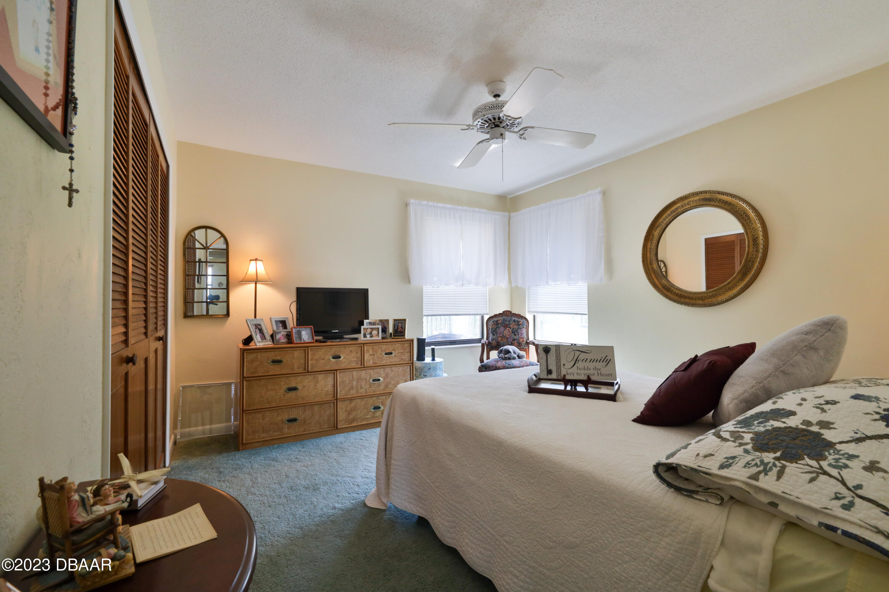 118 Sand Dunes Drive Ormond Beach, FL 32176 - Photo 33 of 46 a living room with furniture a mirror and a flat screen tv