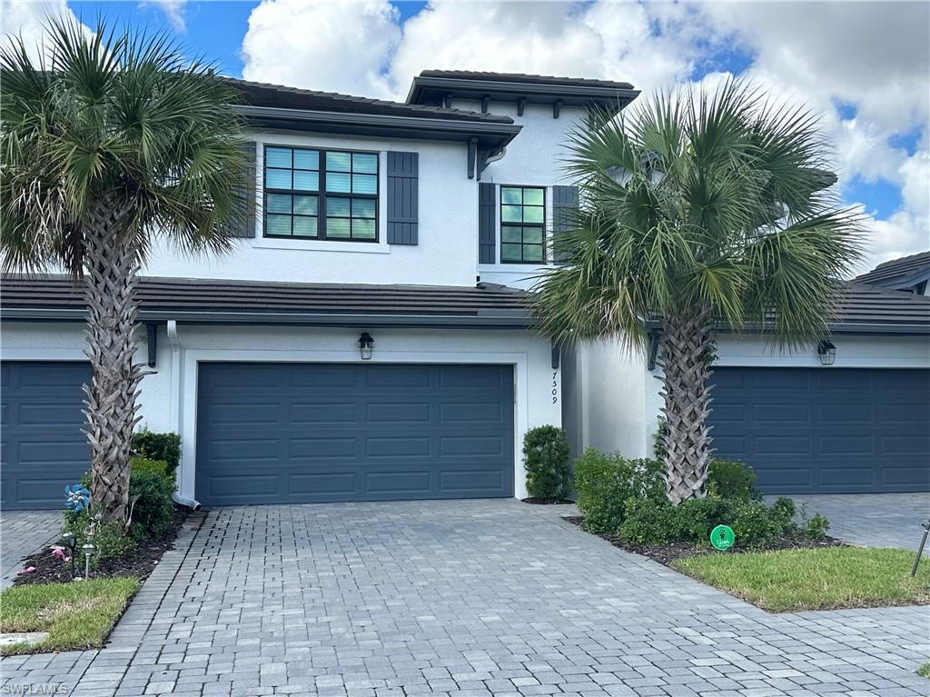 7509 Carnegie Way Naples, FL 34119 - Photo 1 of 33 a front view of a house with a garden