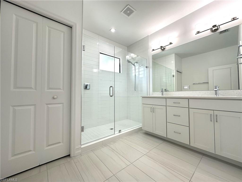 7509 Carnegie Way Naples, FL 34119 - Photo 17 of 33 a spacious bathroom with a shower a sink and mirror