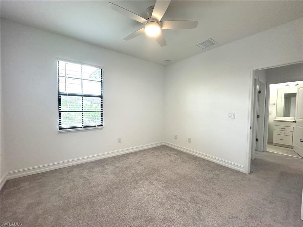 7509 Carnegie Way Naples, FL 34119 - Photo 23 of 33 an empty room with windows and fan