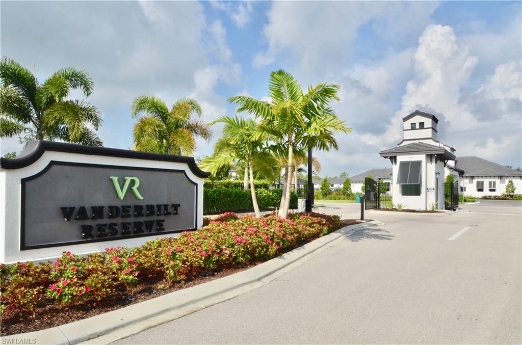 7509 Carnegie Way Naples, FL 34119 - Photo 27 of 33 a front view of a house with a yard and potted plants