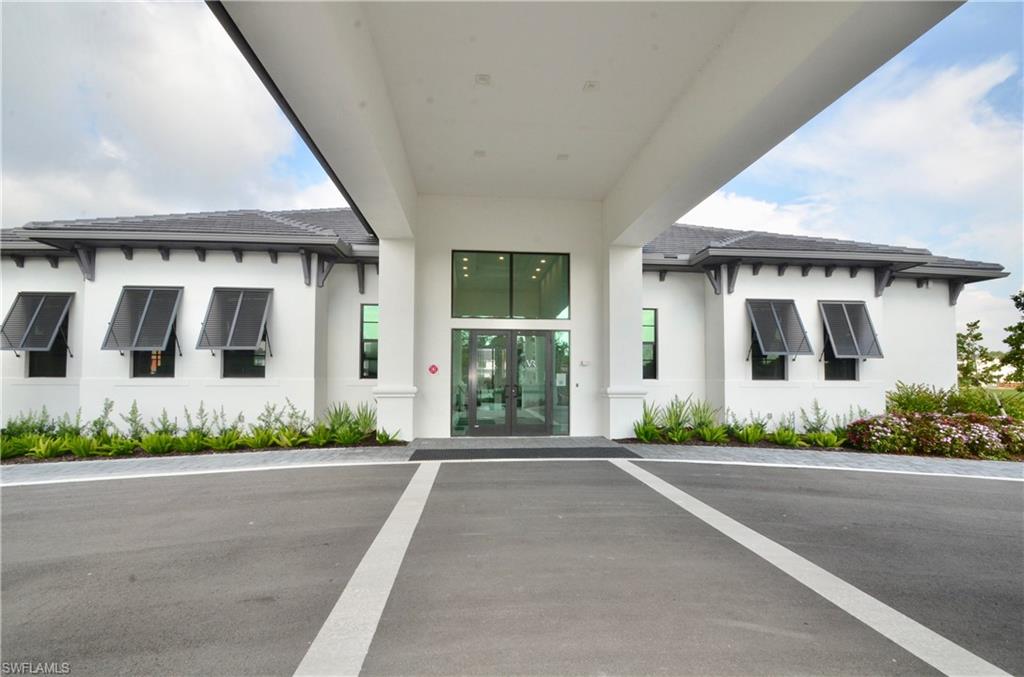 7509 Carnegie Way Naples, FL 34119 - Photo 28 of 33 a front view of a house with a garden and plants