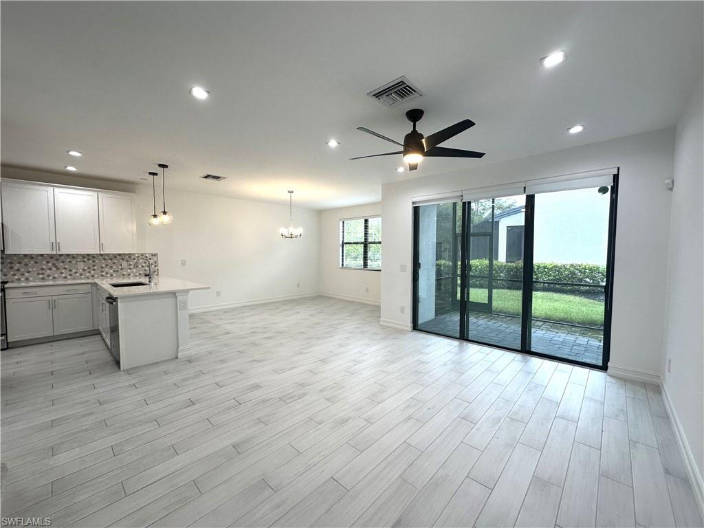 7509 Carnegie Way Naples, FL 34119 - Photo 6 of 33 a view of an empty room with a kitchen