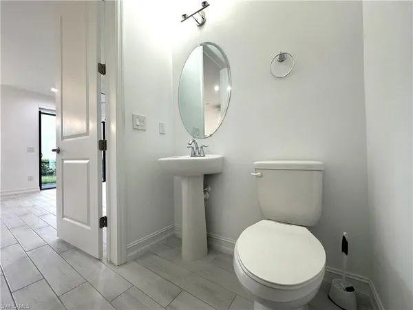 a bathroom with a toilet a sink and mirror
