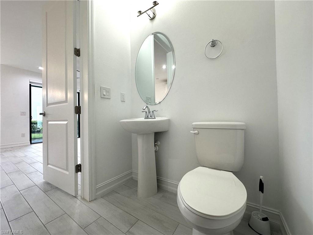 7509 Carnegie Way Naples, FL 34119 - Photo 8 of 33 a bathroom with a toilet a sink and mirror