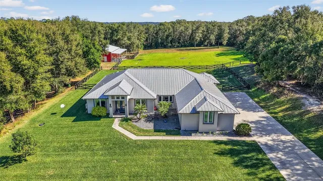 a view of a house with a big yard and potted plants