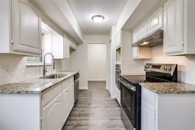 a kitchen with stainless steel appliances granite countertop a sink stove and cabinets