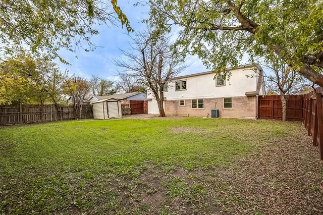 a view of a house with backyard and tree
