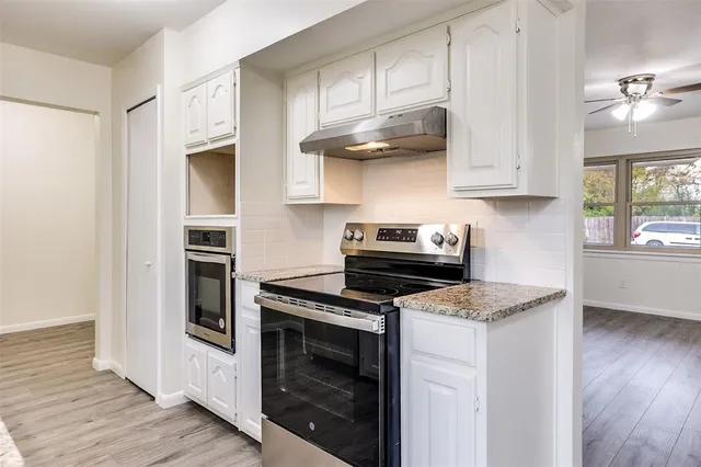 a kitchen with stainless steel appliances granite countertop a sink and a stove