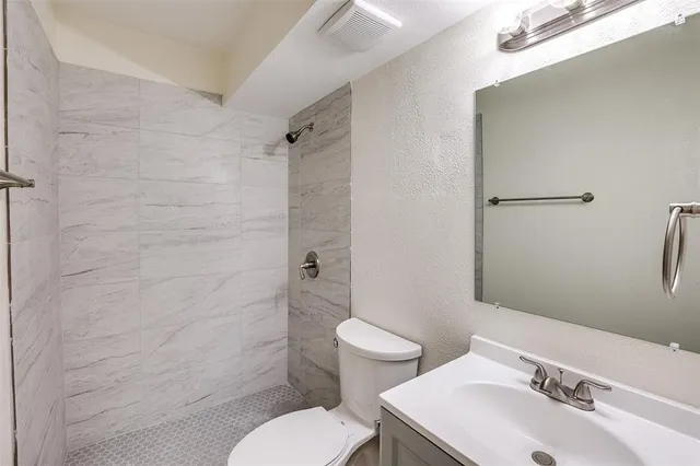 a bathroom with a sink toilet and shower