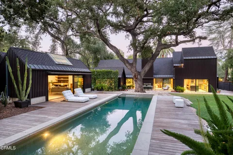 a view of a house with swimming pool and sitting area
