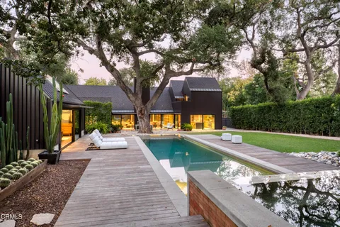 a view of a patio with chairs and a large tree