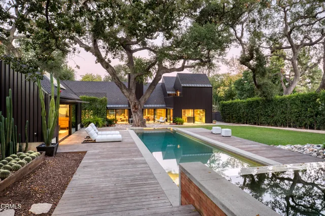 a view of a patio with chairs and a large tree