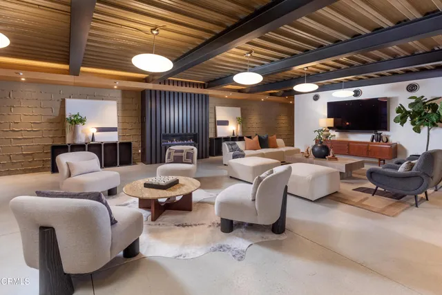 a living room with patio furniture and a large window