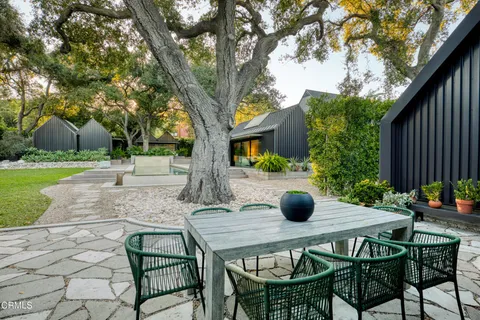 a view of pool with lawn chairs and large trees