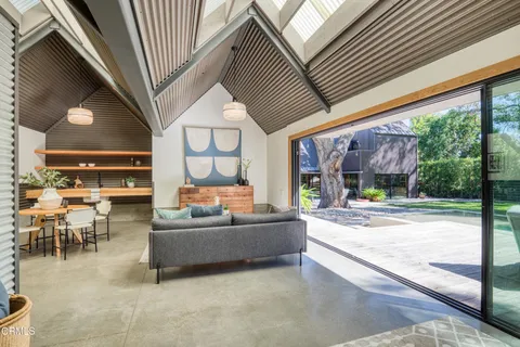 a view of a house with backyard and a tree
