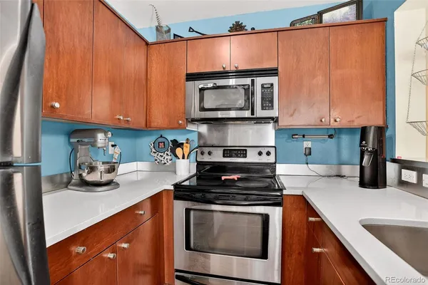 a kitchen with stainless steel appliances granite countertop a stove a sink and a microwave